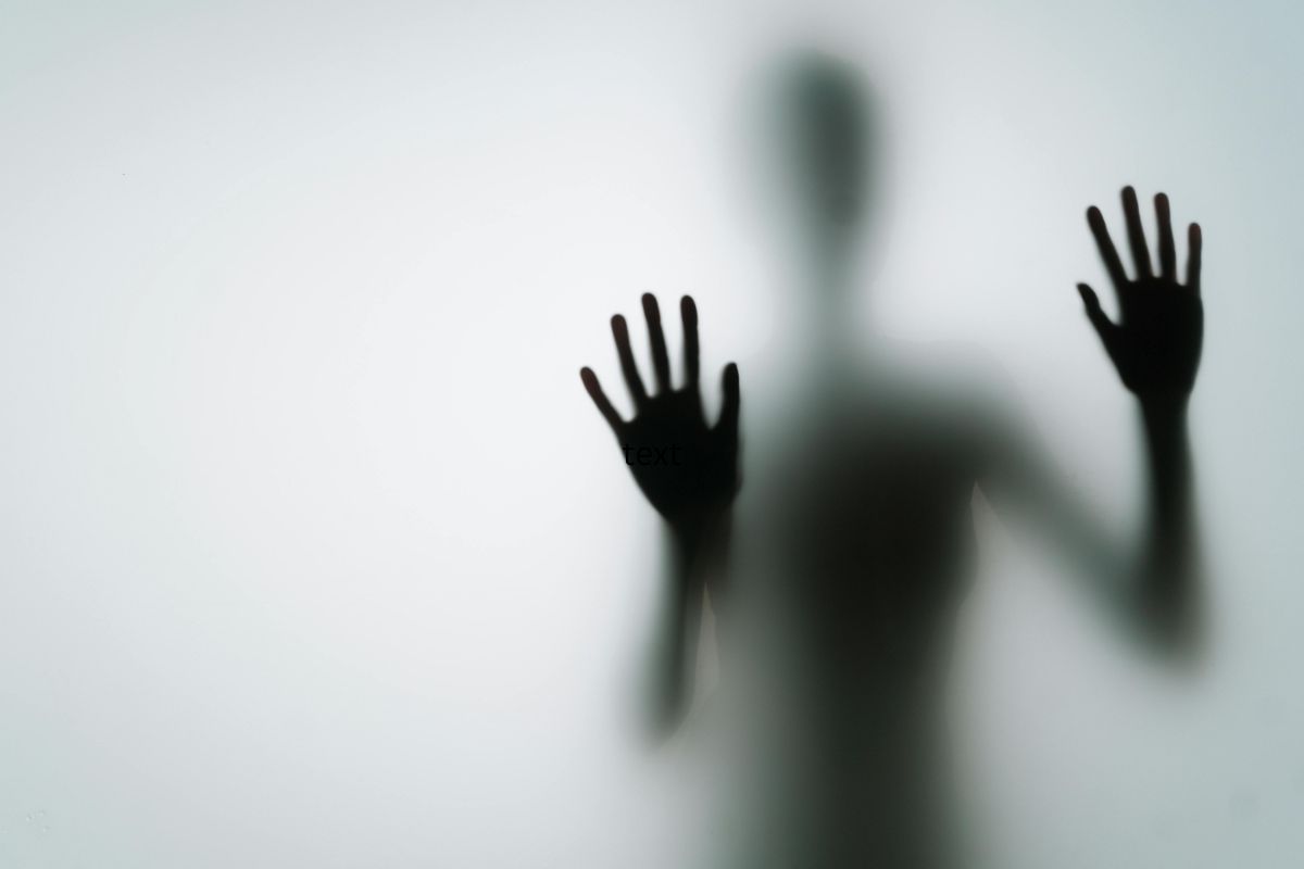 Person peering through frosted glass