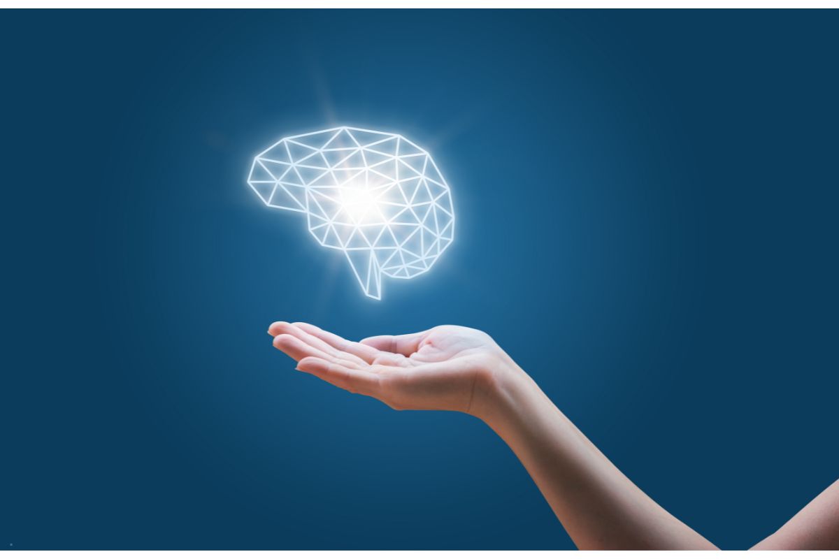 Hand holding a graphic of a brain