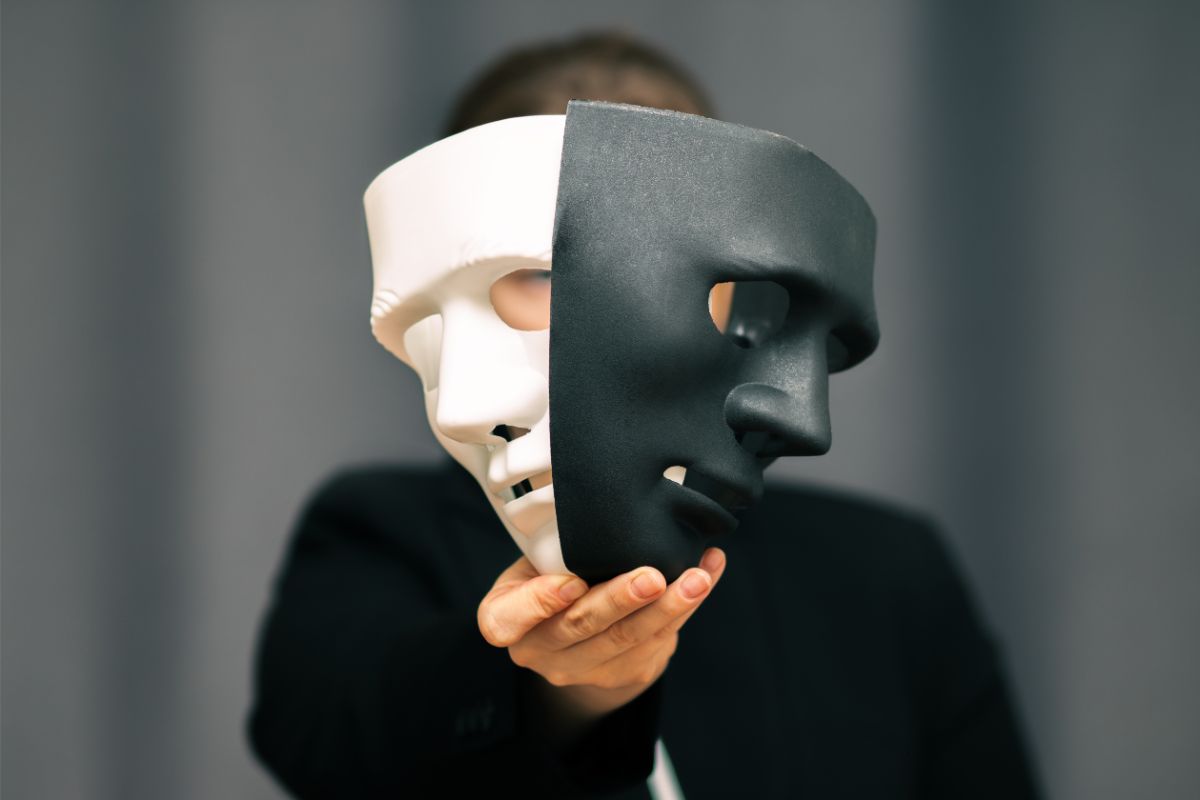 Man hiding behind two masks.